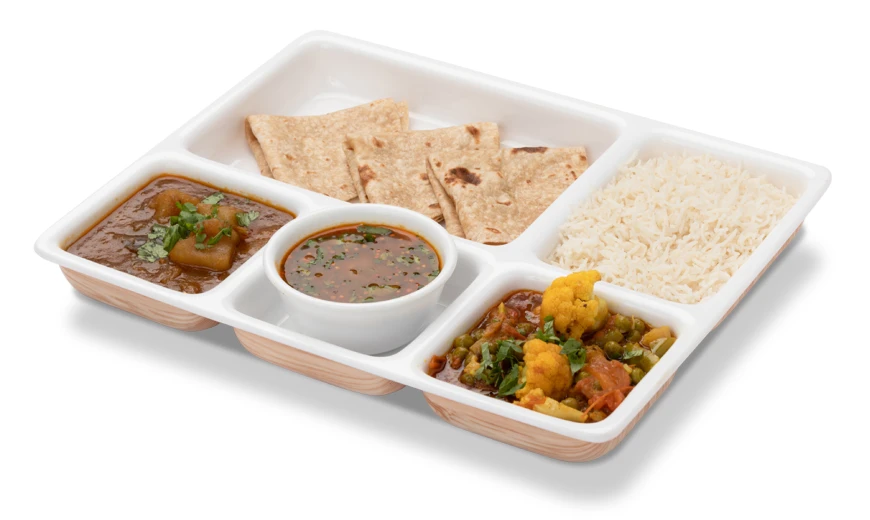 Neehee's Gujarati Thali. A white tray with five sections holding an Indian meal, including rice, roti, vegetable curry, dal, and another curry with peas and cauliflower.
